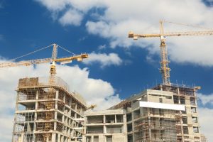 2 cranes operating on a building under construction